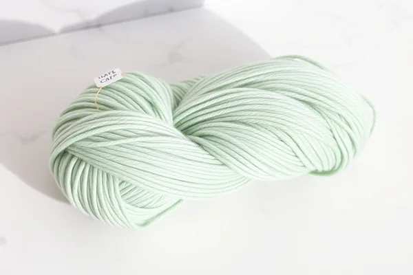 Mérinos DK Superwash — pelote vert sauge sur marbre blanc